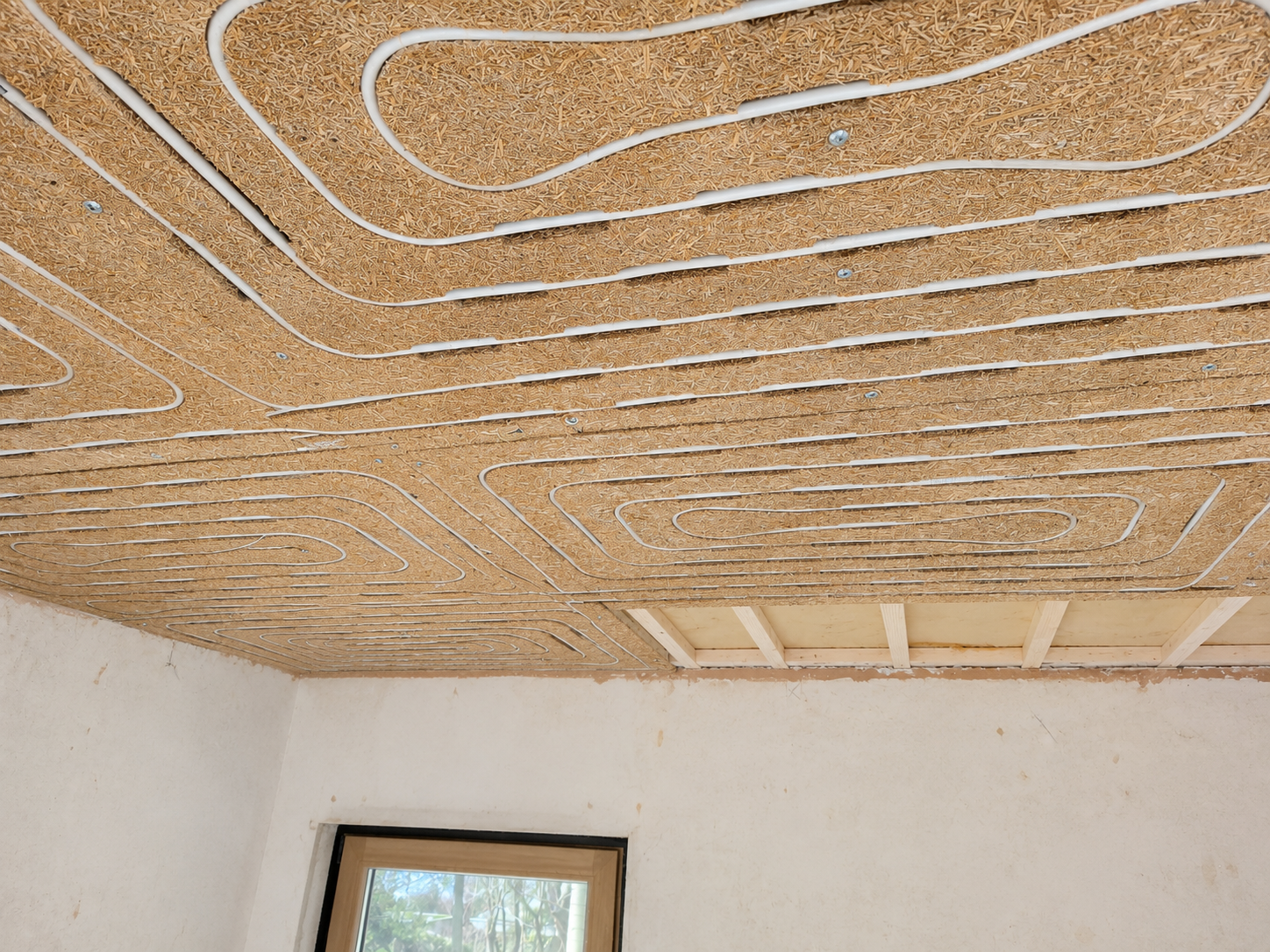 Uniwarm Healture Deckenheizung w&auml;hrend der Montage. Das biobasierte Deckenmodul mit integrierten Heizrohren ist vor der Endmontage sichtbar und bildet die Grundlage f&uuml;r ein energieeffizientes System zum Heizen und K&uuml;hlen.