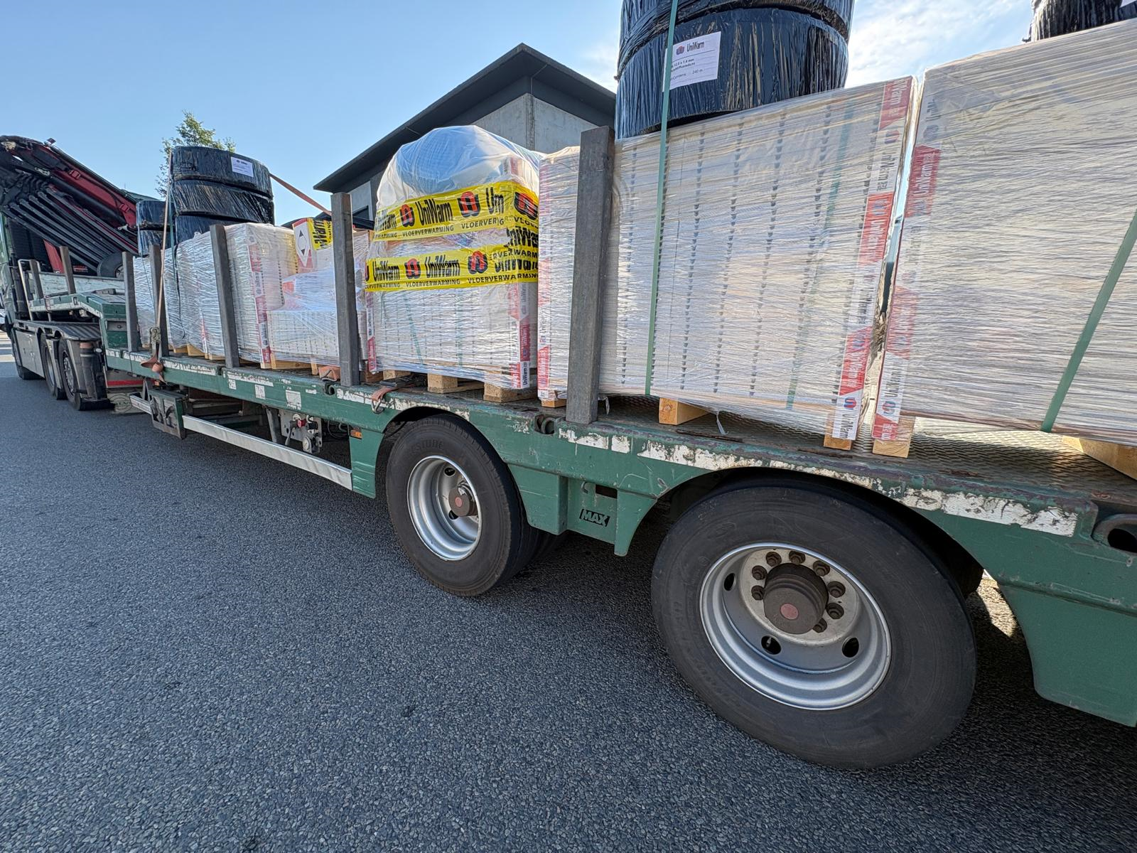 Vrachtwagen geladen met het droogbouw vloerverwarmingssysteem van Uniwarm voor levering aan een monumentaal renovatieproject.